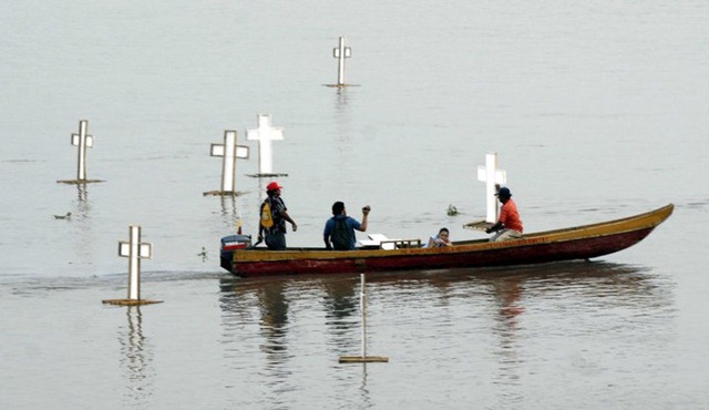 Fotografía de los pobladores colocando las cruces en conmemoración a las muertes ocurridas en la masacre de obreros.